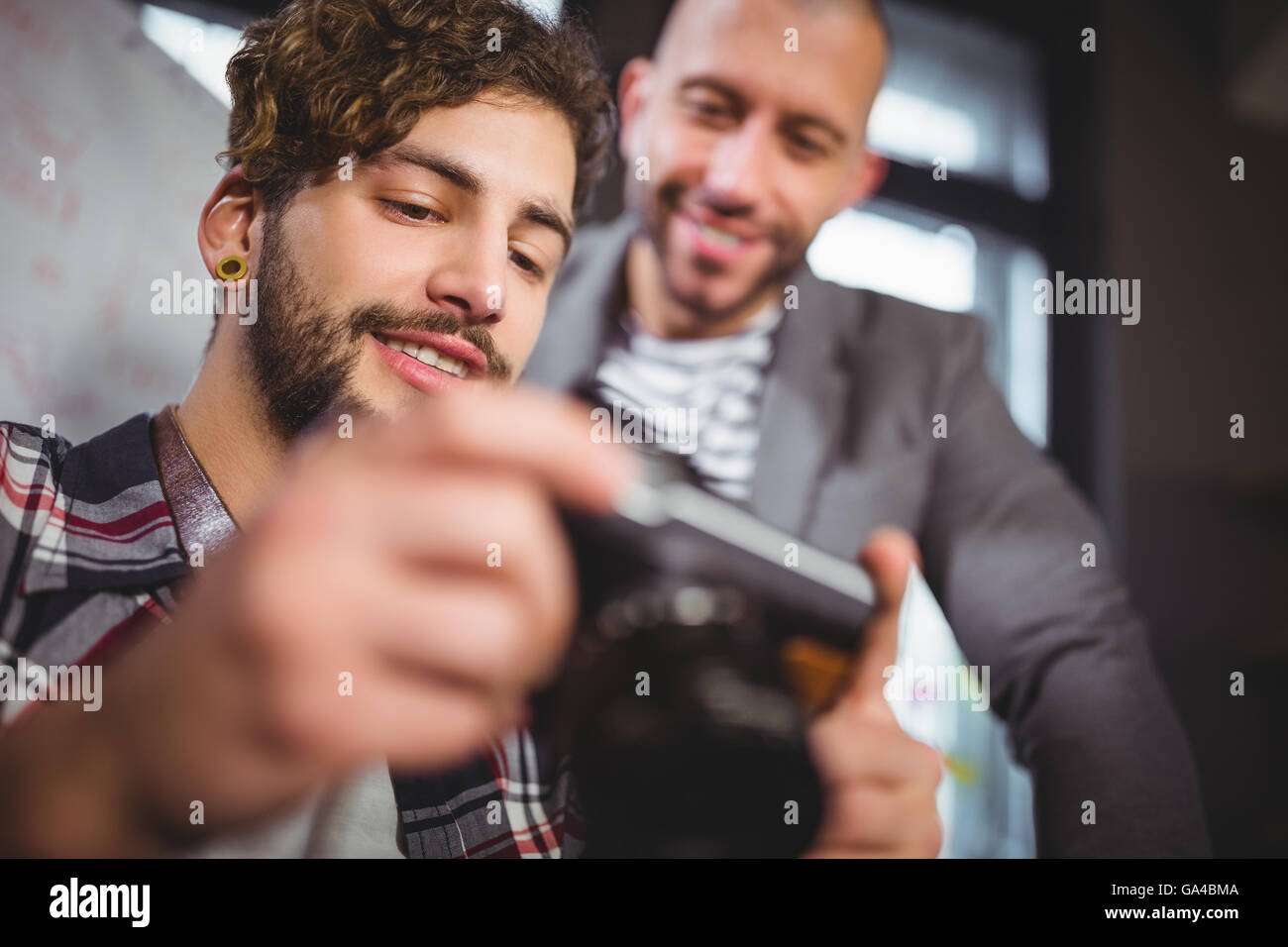 Male colleagues smiling while looking in camera Stock Photo
