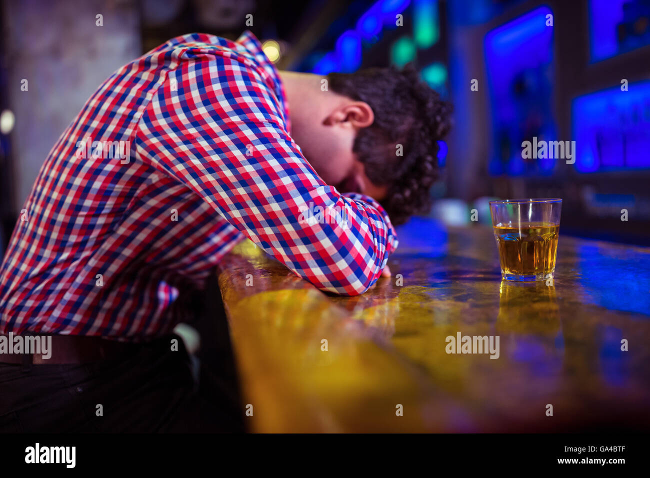 Drunk man lying on bar counter Stock Photo