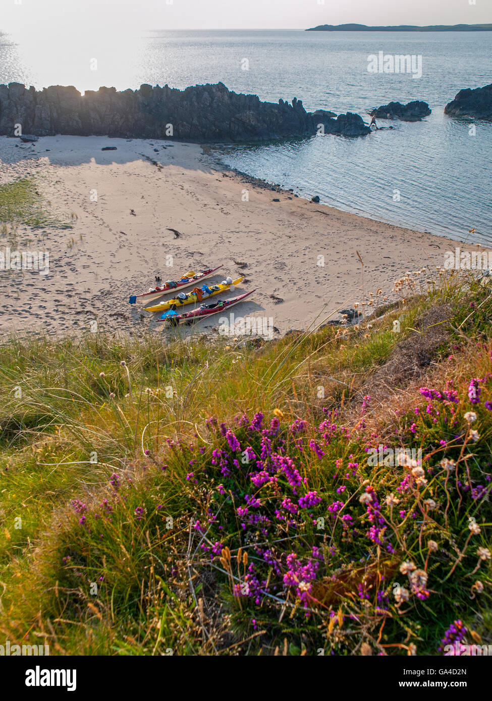 3 sea kayaks on a beach on Llanddwyn Island , Anglesey, Wales,UK Stock Photo