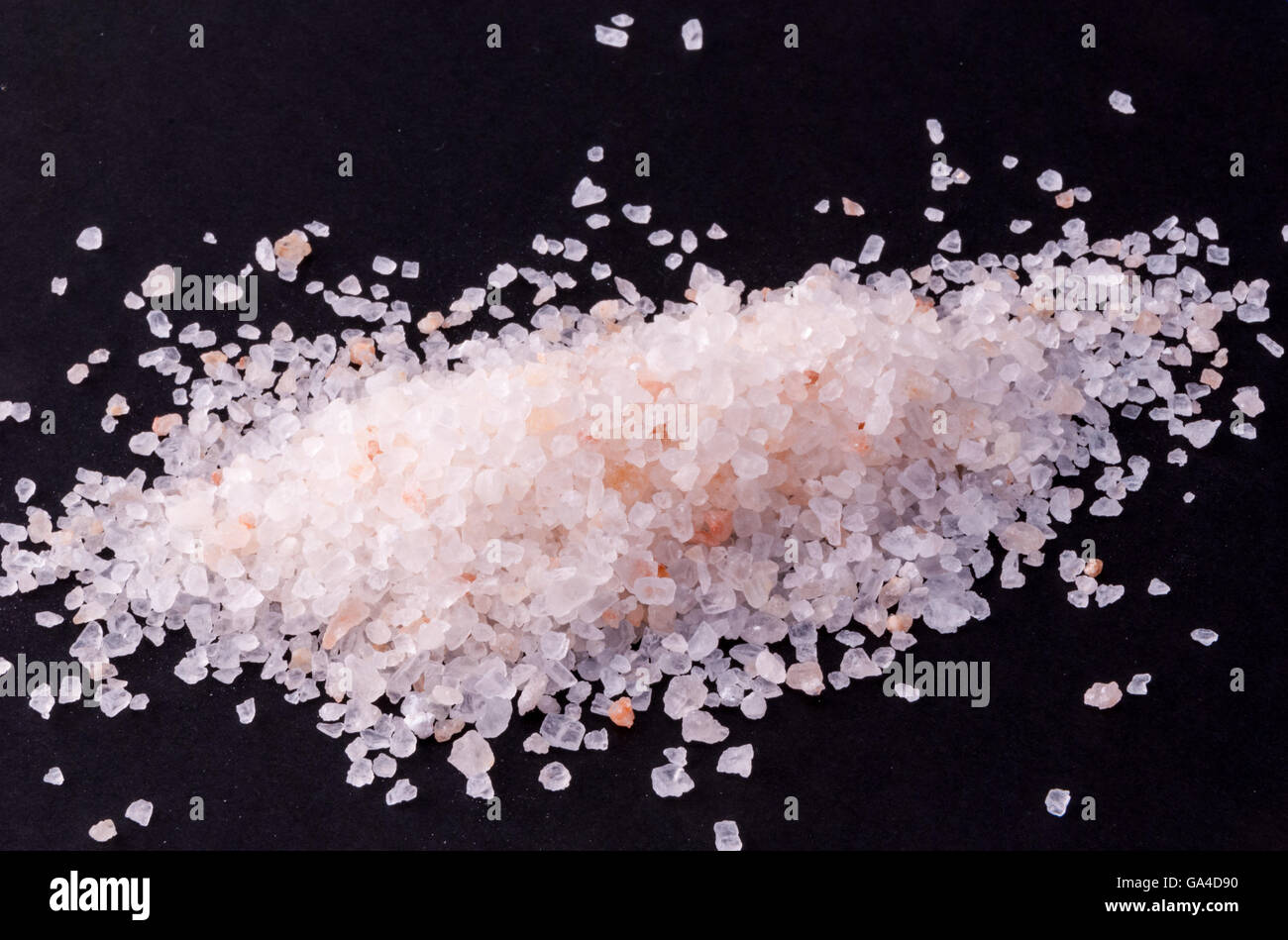 Coarse-grained salt from the Himalayas on black background Stock Photo