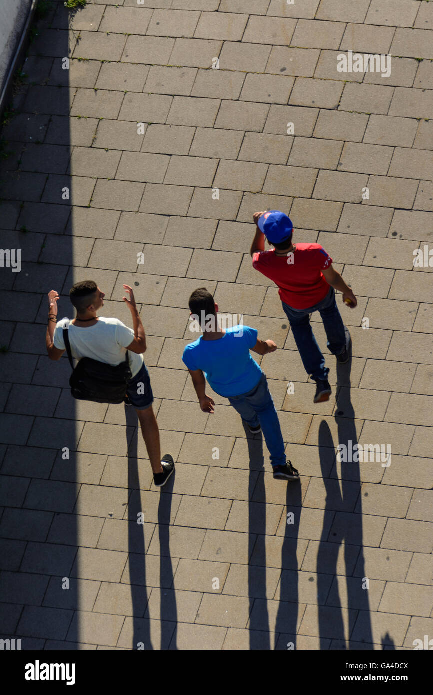 Wien, Vienna 3 teenage boys walking and chatting, long shadows Austria Wien Stock Photo