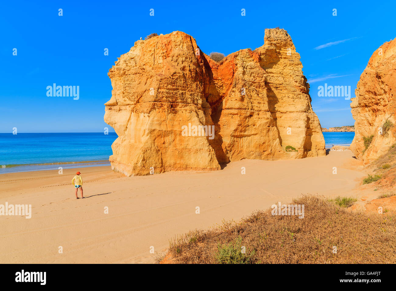Tourist standing on beautiful Praia da Rocha beach, Algarve region, Portugal Stock Photo