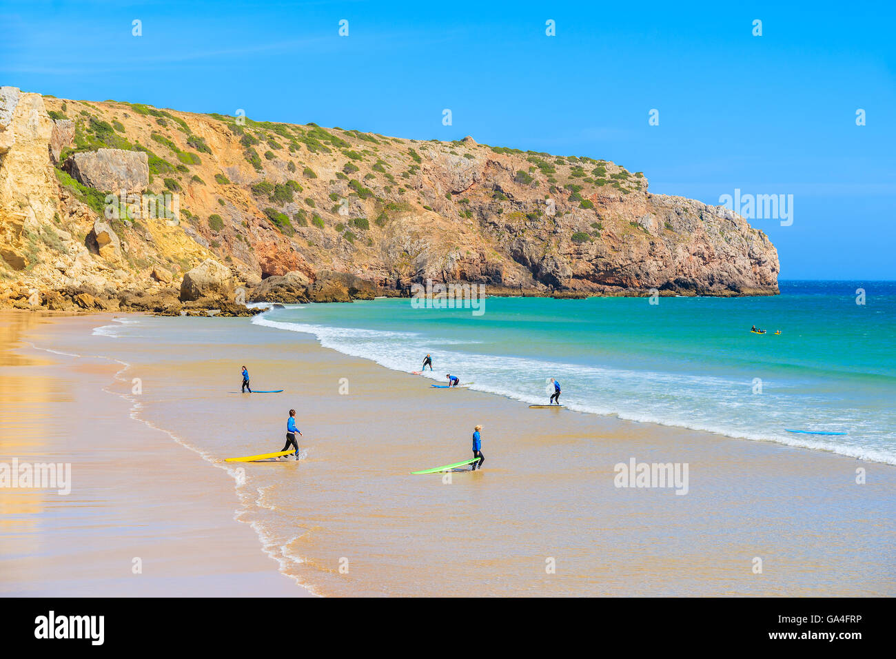 Surfers on sandy Zavial beach, Portugal Stock Photo
