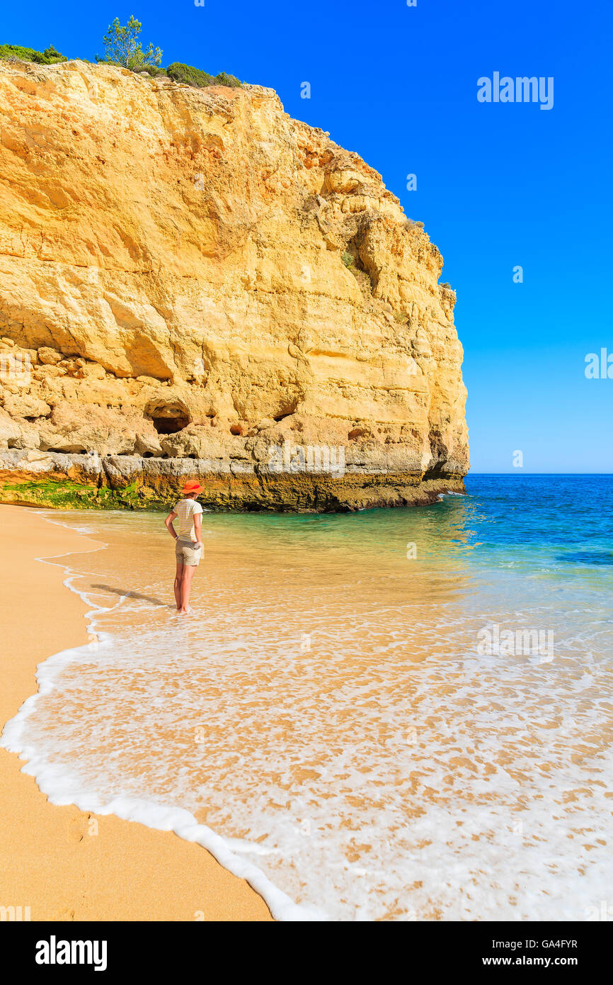 Young woman tourist standing in water of sea wave on Vale Centianes beach, Portugal Stock Photo