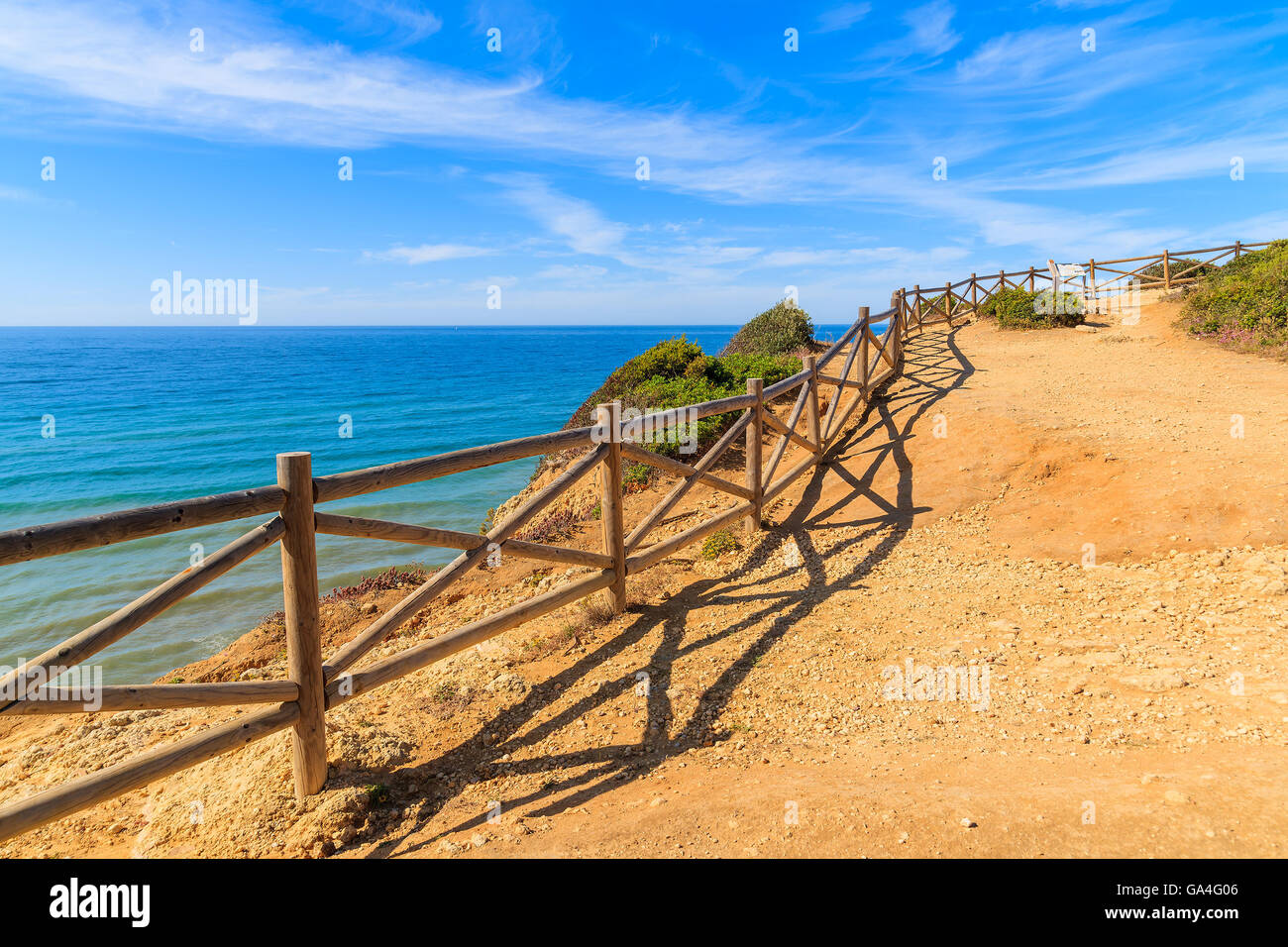 Wooden fence on cliff path on coast of Portugal in Algarve region near Praia de Marinha beach Stock Photo