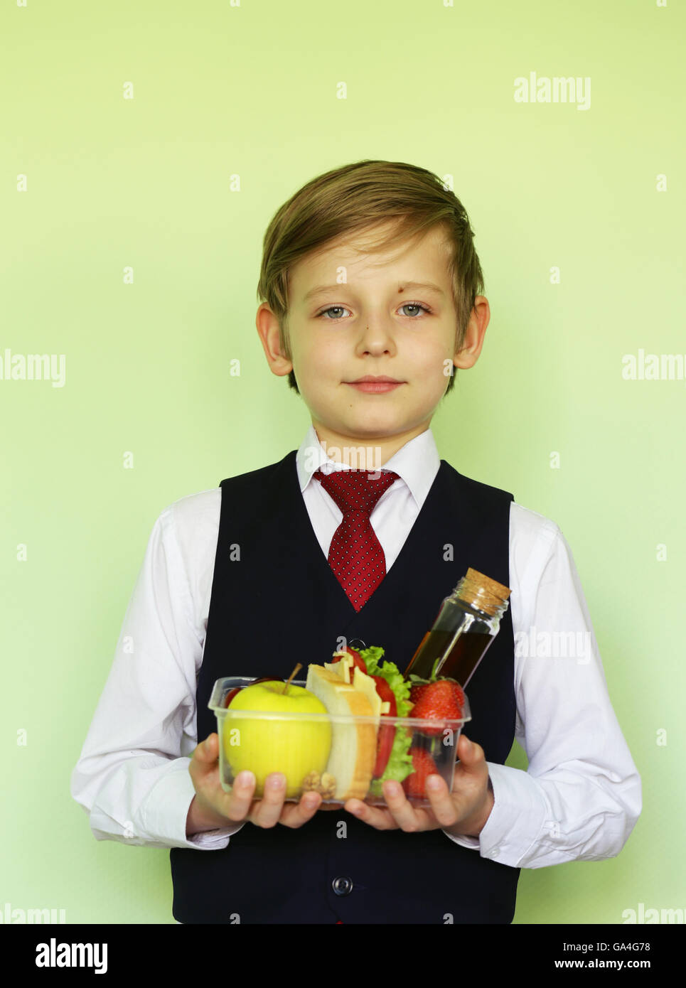 Boy in school uniform and lunch box with sandwich and fruits healthy