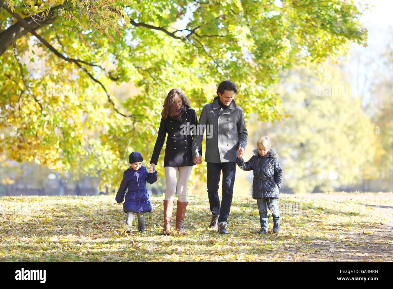 Happy family walking in autumn park at sunny day Stock Photo - Alamy