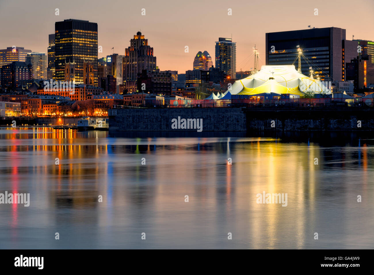 Montreal Old Port at dusk reflected in the St Lawrence river, with the Cirque de Soleil tent Stock Photo