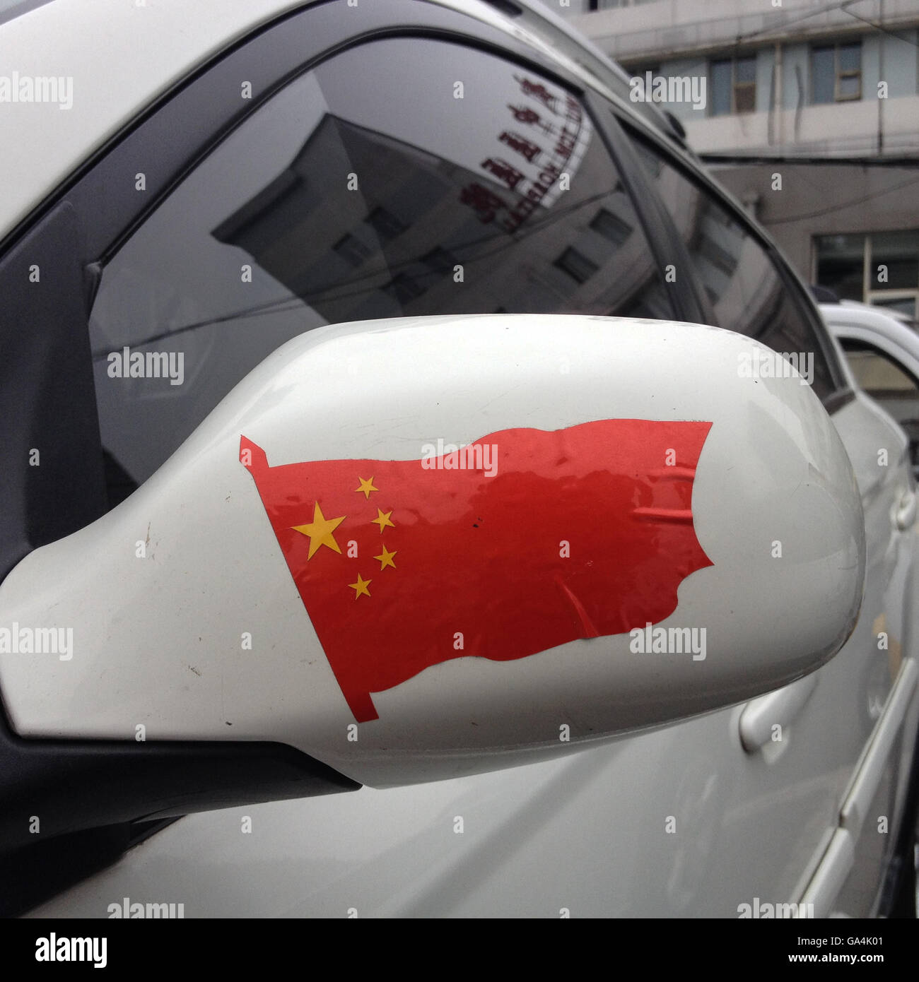 Chinese flag sticker on the wing mirror of a car, in Beijing, China. Stock Photo