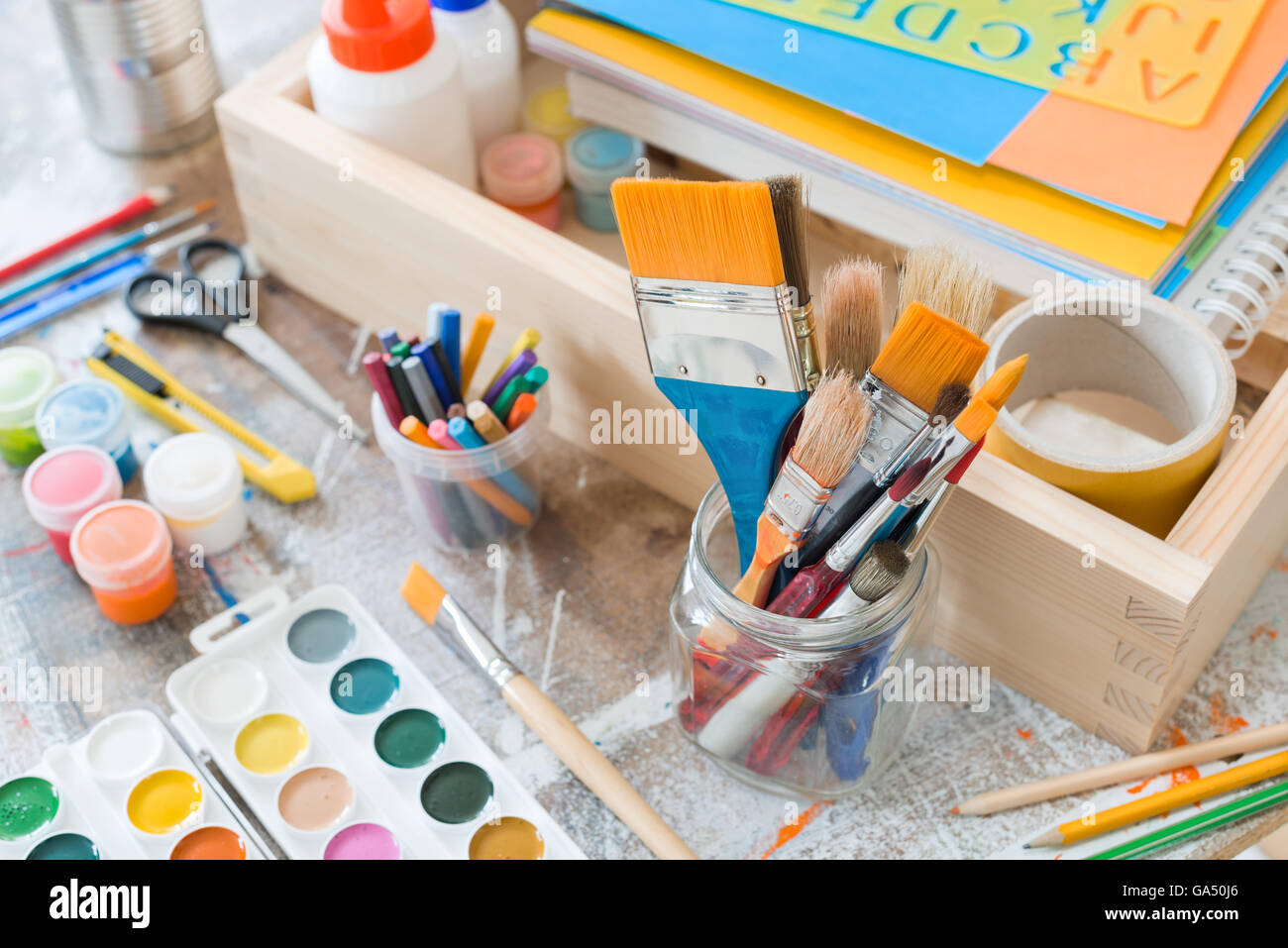 https://c8.alamy.com/comp/GA50J6/paint-brushes-and-crafting-supplies-on-the-table-in-a-workshop-GA50J6.jpg