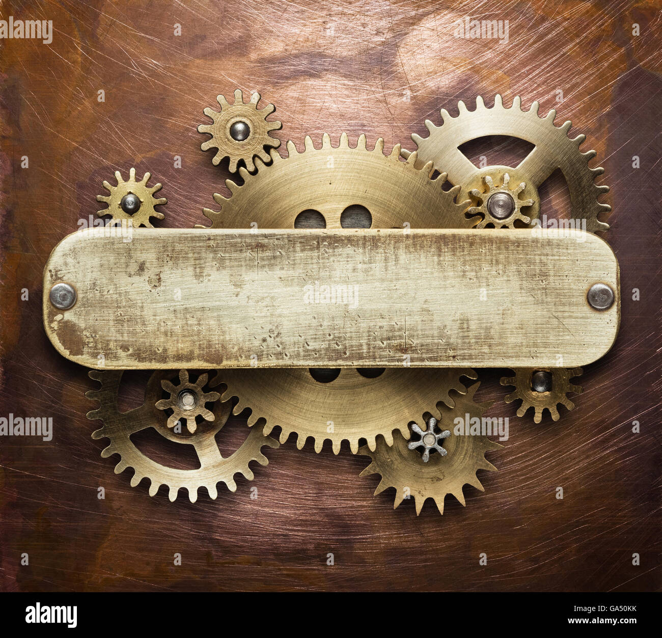 Clockwork mechanism collage on copper background made of metal gears, brass plate. Stock Photo