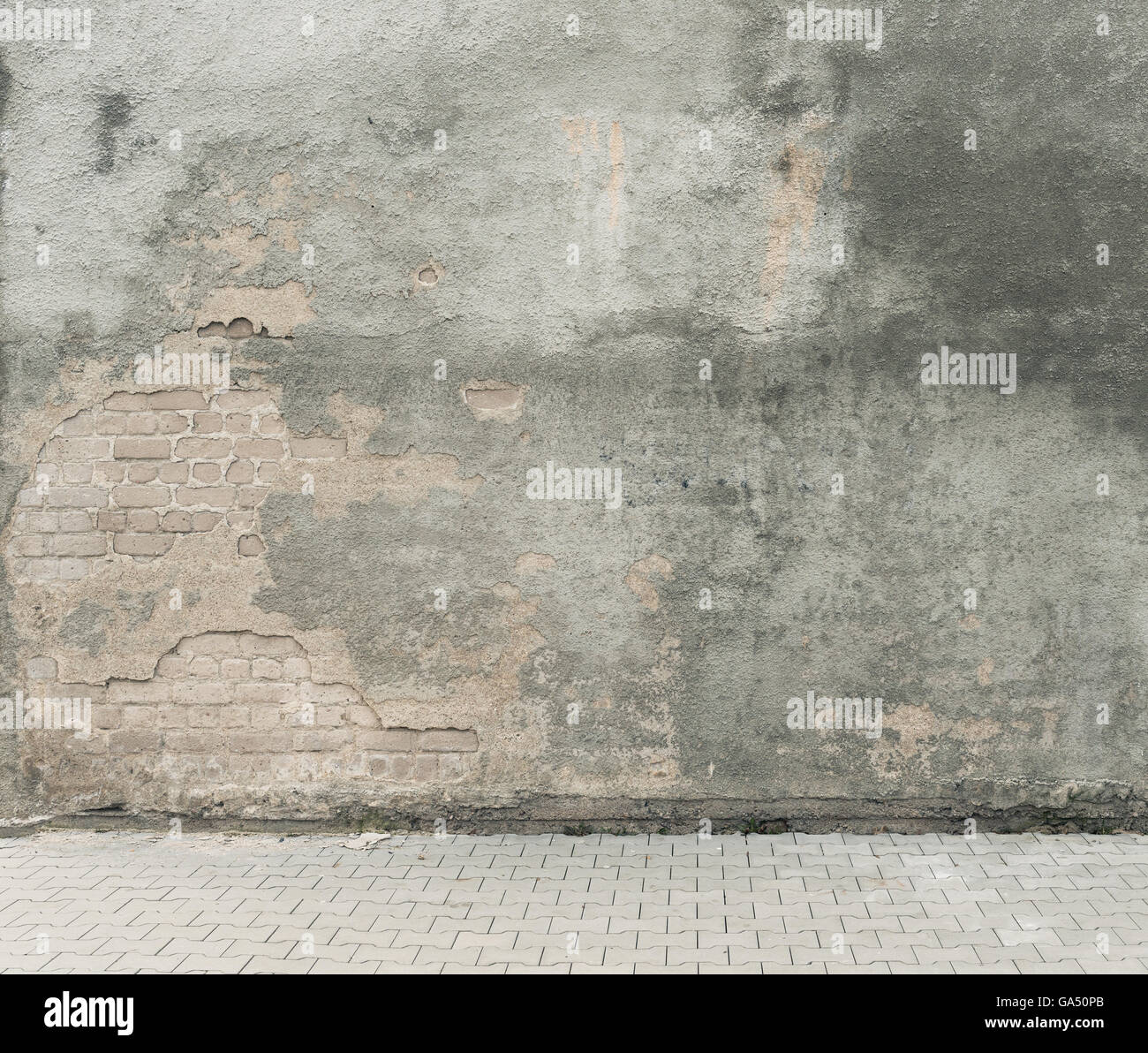 Urban background. Grunge obsolete street wall and pavement. Stock Photo