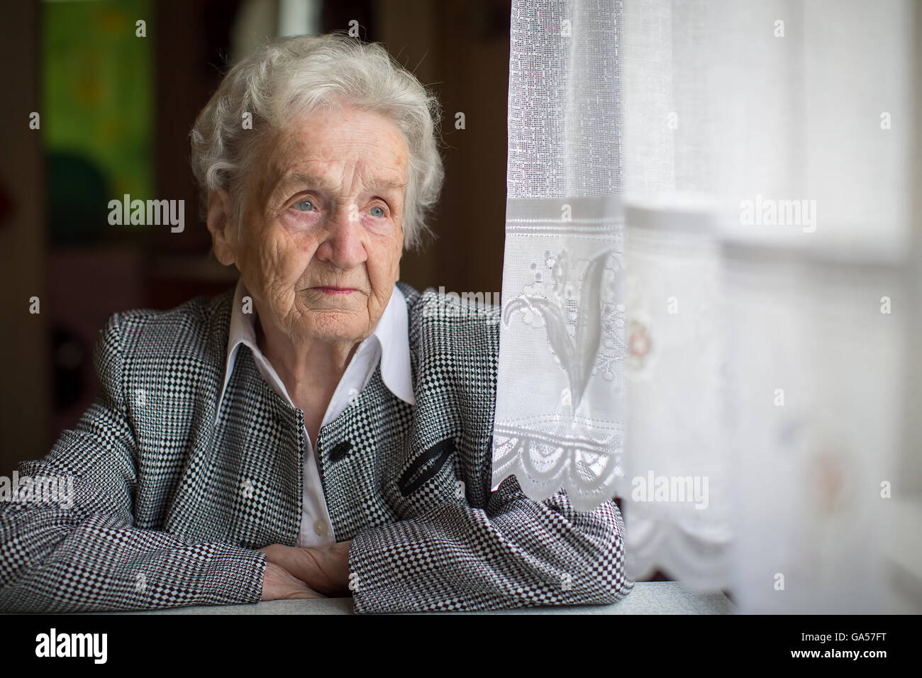 Elderly woman portrait, sitting in the house. Stock Photo