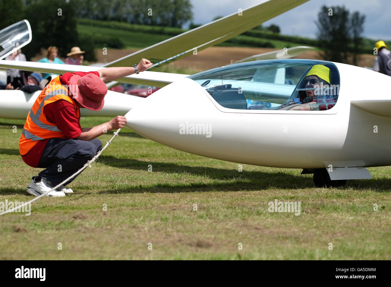 Shobdon airfield, Herefordshire, UK - July 2016 - Ground crew connect an aero tow rope to a glider in preparation for launching on Day 2 of the Competition Enterprise gliding event. Stock Photo