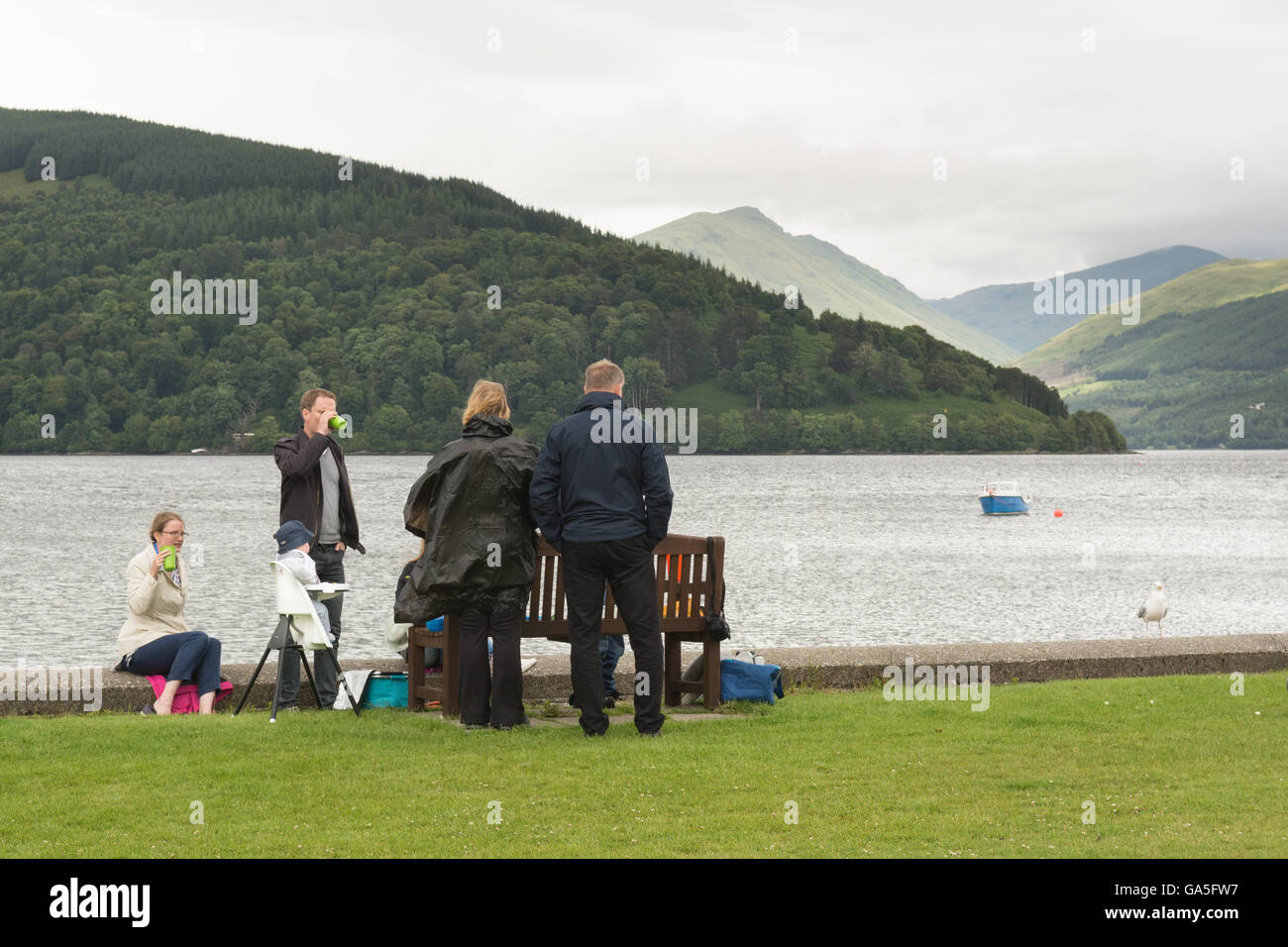 Inveraray, Argyll and Bute, Scotland, UK. 3rd July, 2016. UK Weather: Despite it being a cool, windy and cloudy day with occasional rain showers, this well organised picnic still went ahead on the shores of Loch Fyne Credit:  Kay Roxby/Alamy Live News Stock Photo