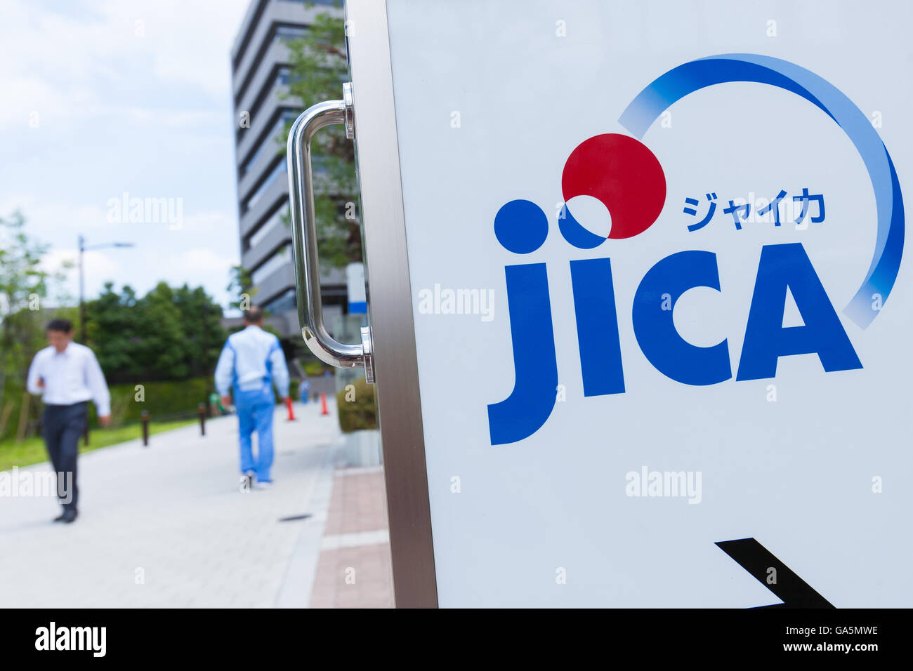 Pedestrians walk past a JICA signboard on display outside its Ichigaya building in Tokyo on July 4, 2016, Japan. Seven Japanese working on a transportation infrastructure project managed by the International Cooperation Agency (JICA) were among 28 who died in a terrorist attack on a cafe in Bangladesh's capital, Dhaka, on July 1st. The Japanese Prime Minister Shinzo Abe expressed his anger over the attack calling it an unforgivable act of terrorism and JICA's President Shinichi Kitaoka also expressed his grief after hearing that seven Japanese had been killed. (Photo by Rodrigo Reyes Marin/AFL Stock Photo