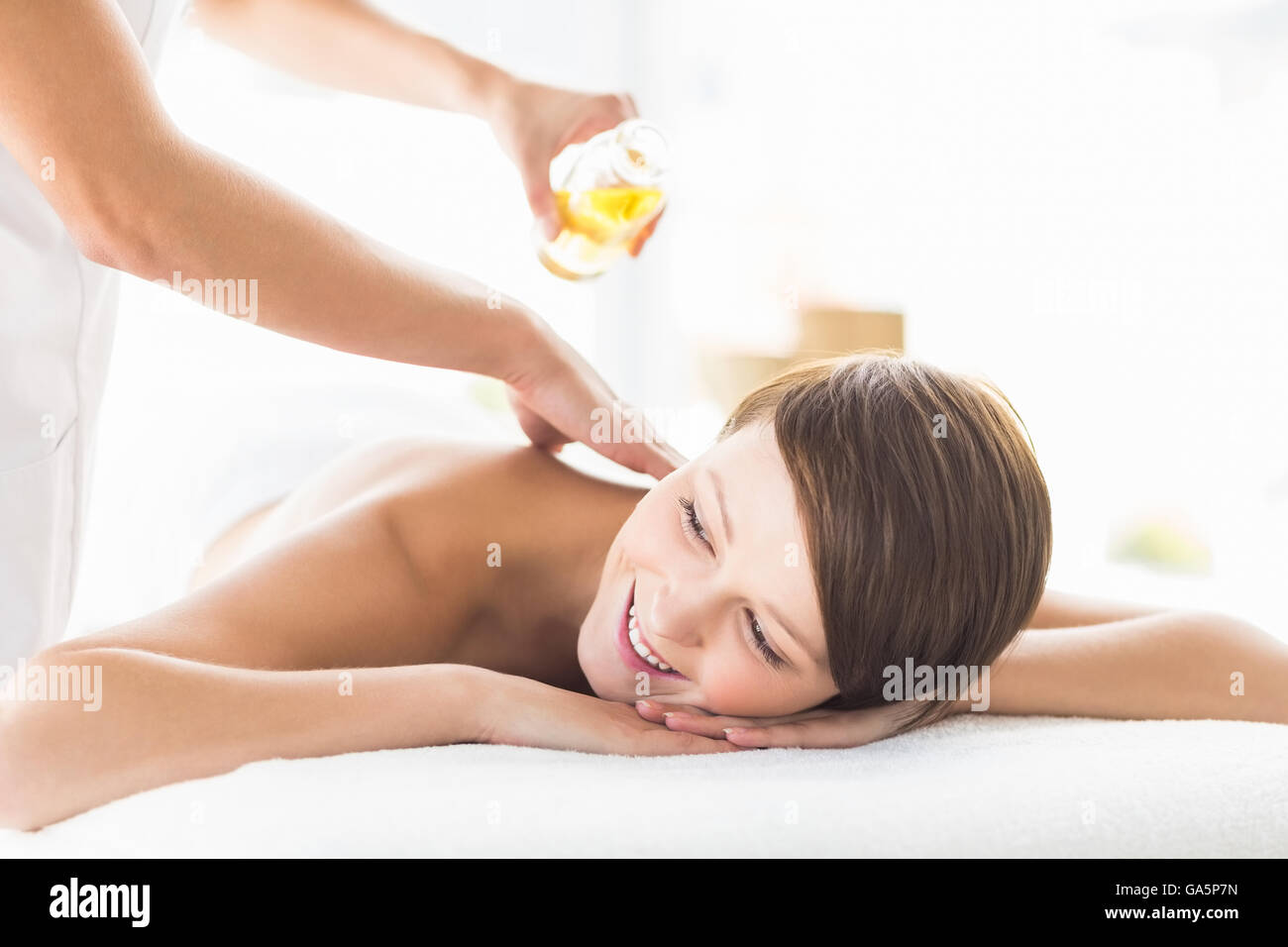 Masseur pouring massage oil on woman Stock Photo