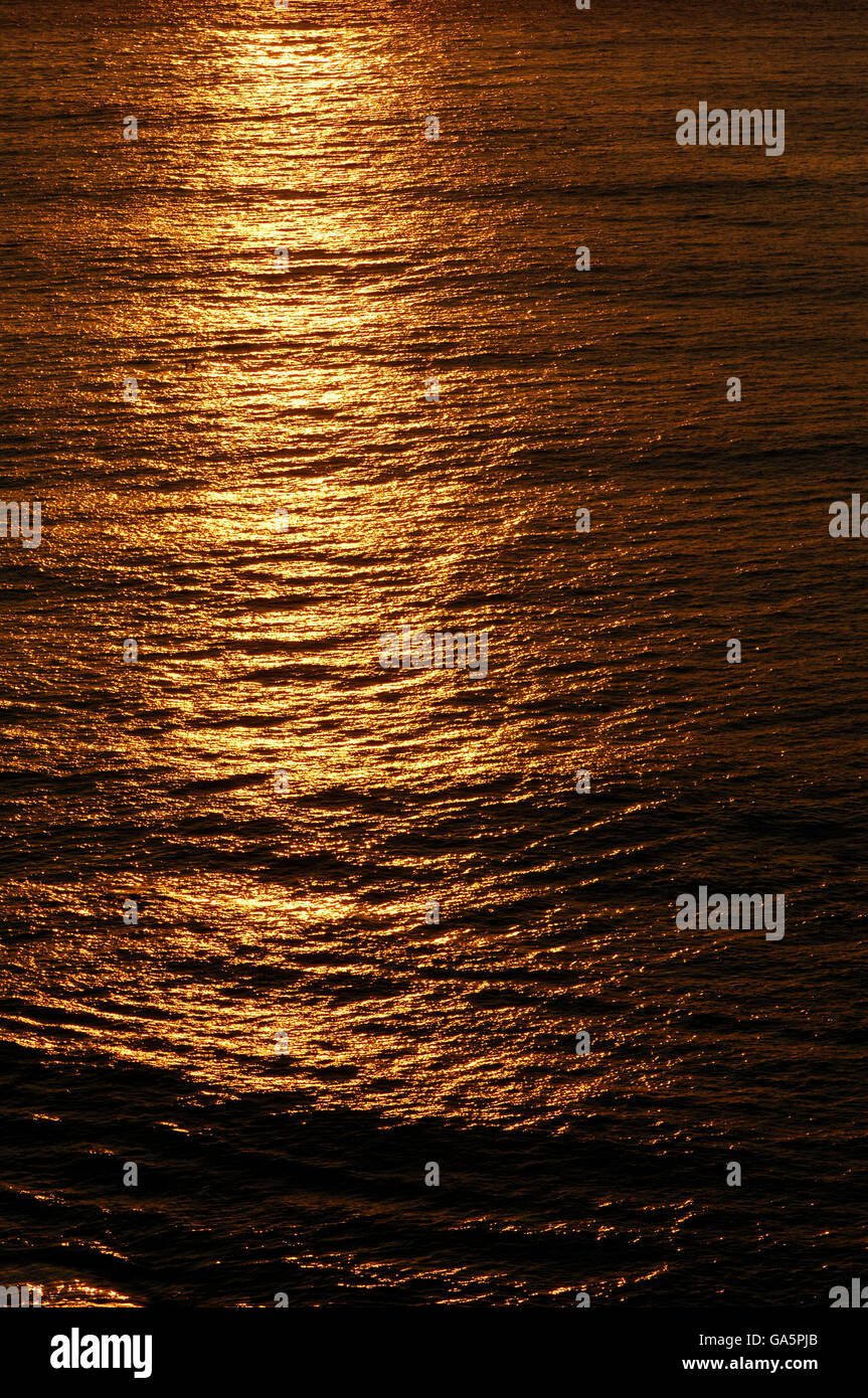 Golden reflections off the ocean at Sunset Stock Photo - Alamy