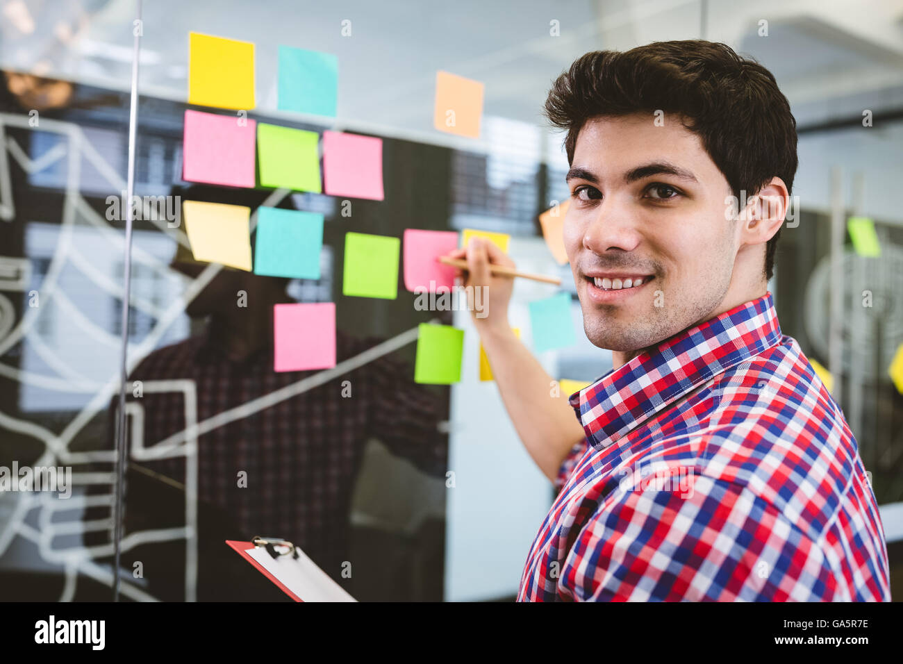 Businessman writing on sticky notes Stock Photo - Alamy