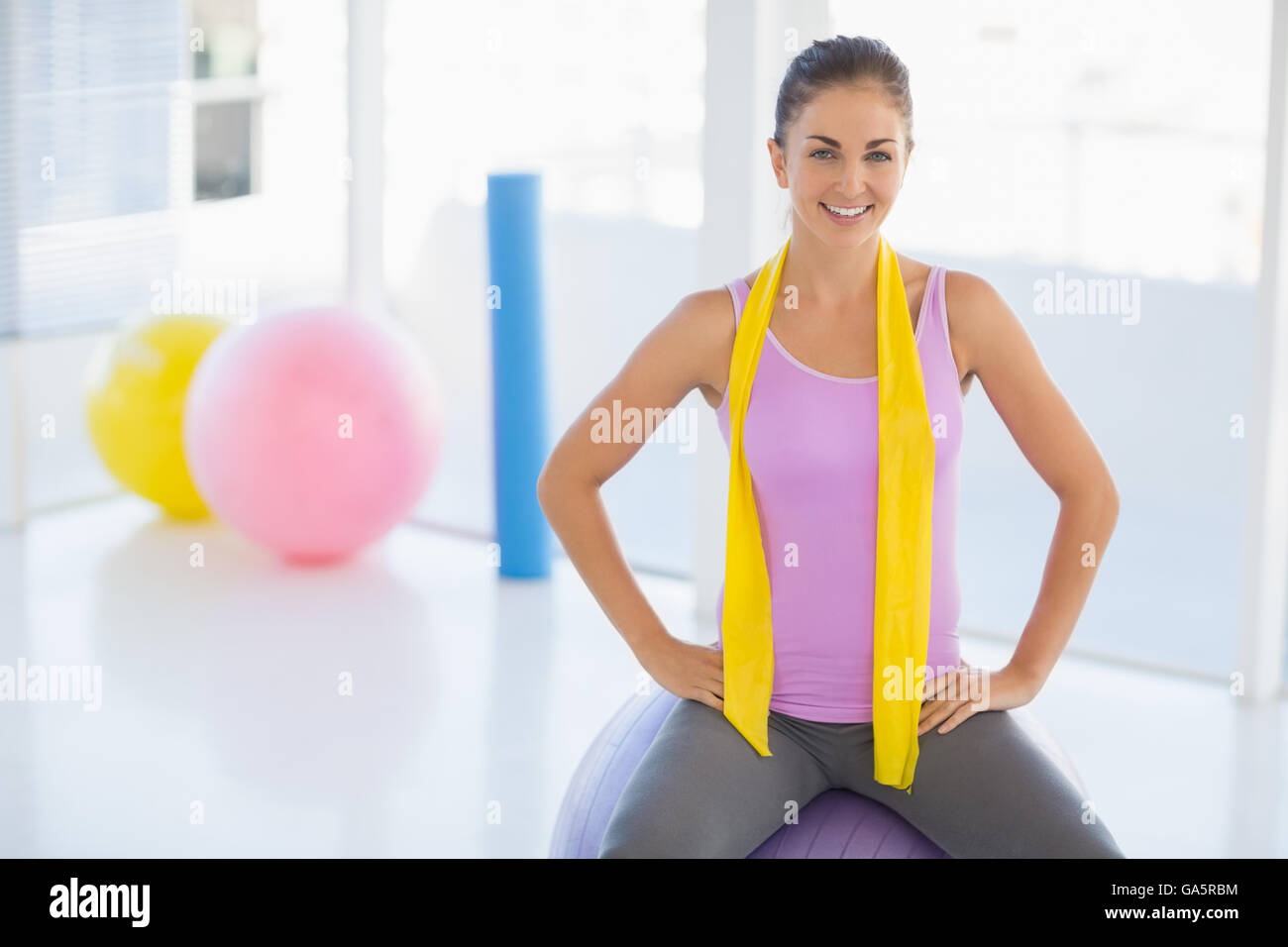 Portrait of happy woman sitting on exercise ball Stock Photo - Alamy