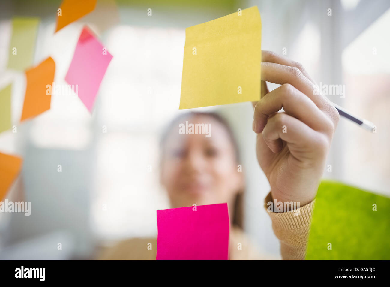 Businesswoman writing on adhesive note Stock Photo