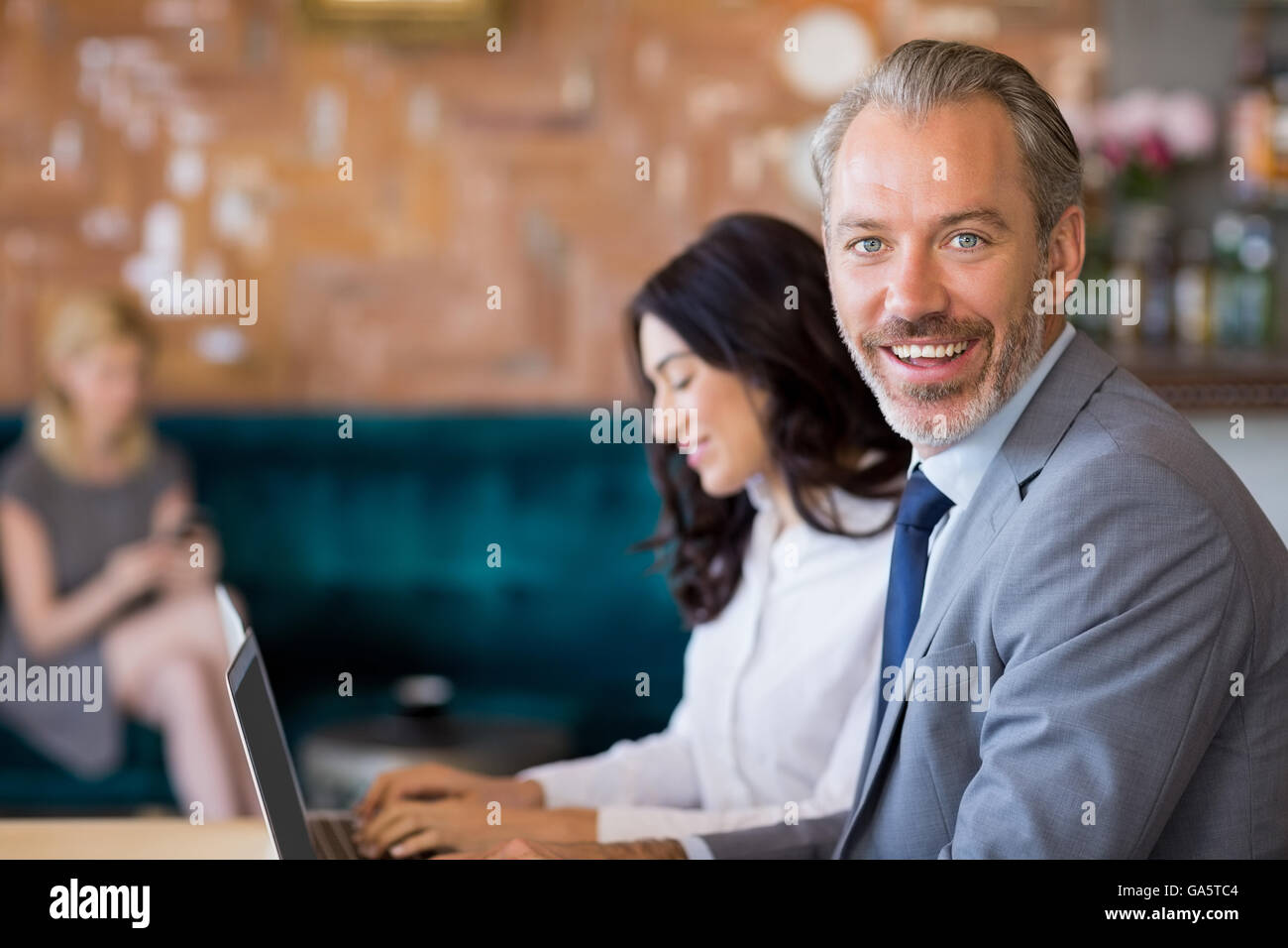 Business colleagues sitting on table and using laptop Stock Photo