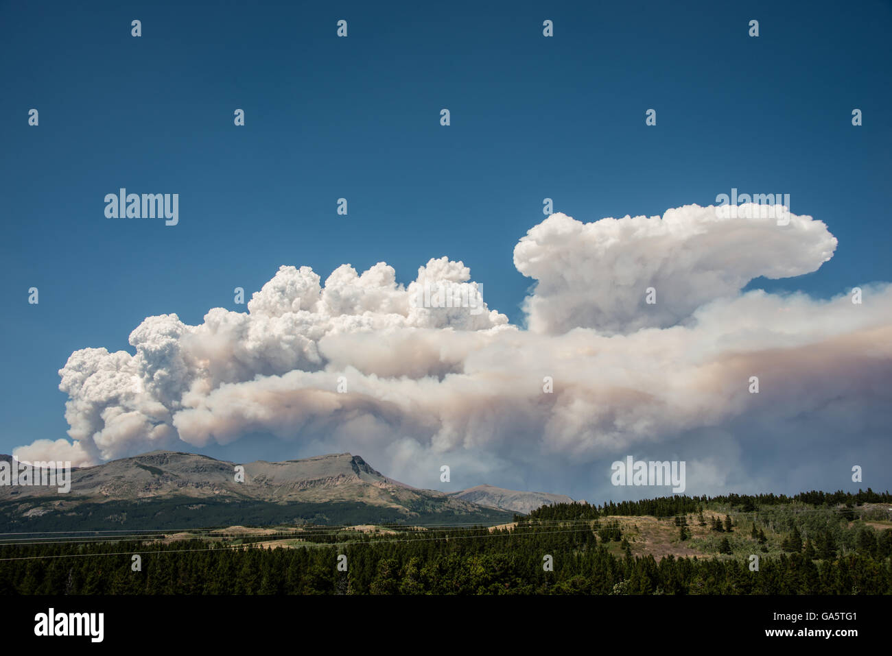 Smoke rises from a forest fire in Glacier National Park, Montana. Stock Photo