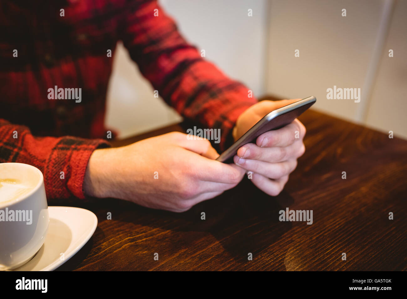 Midsection of man using mobile phone in restaurant Stock Photo