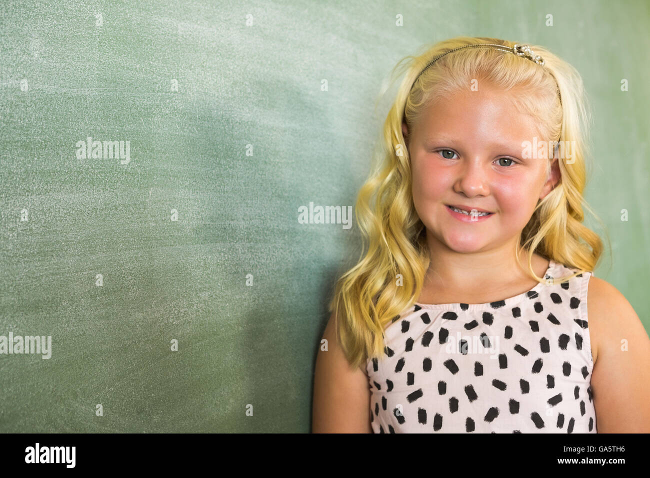 Portrait of smiling schoolgirl standing in classroom Stock Photo - Alamy