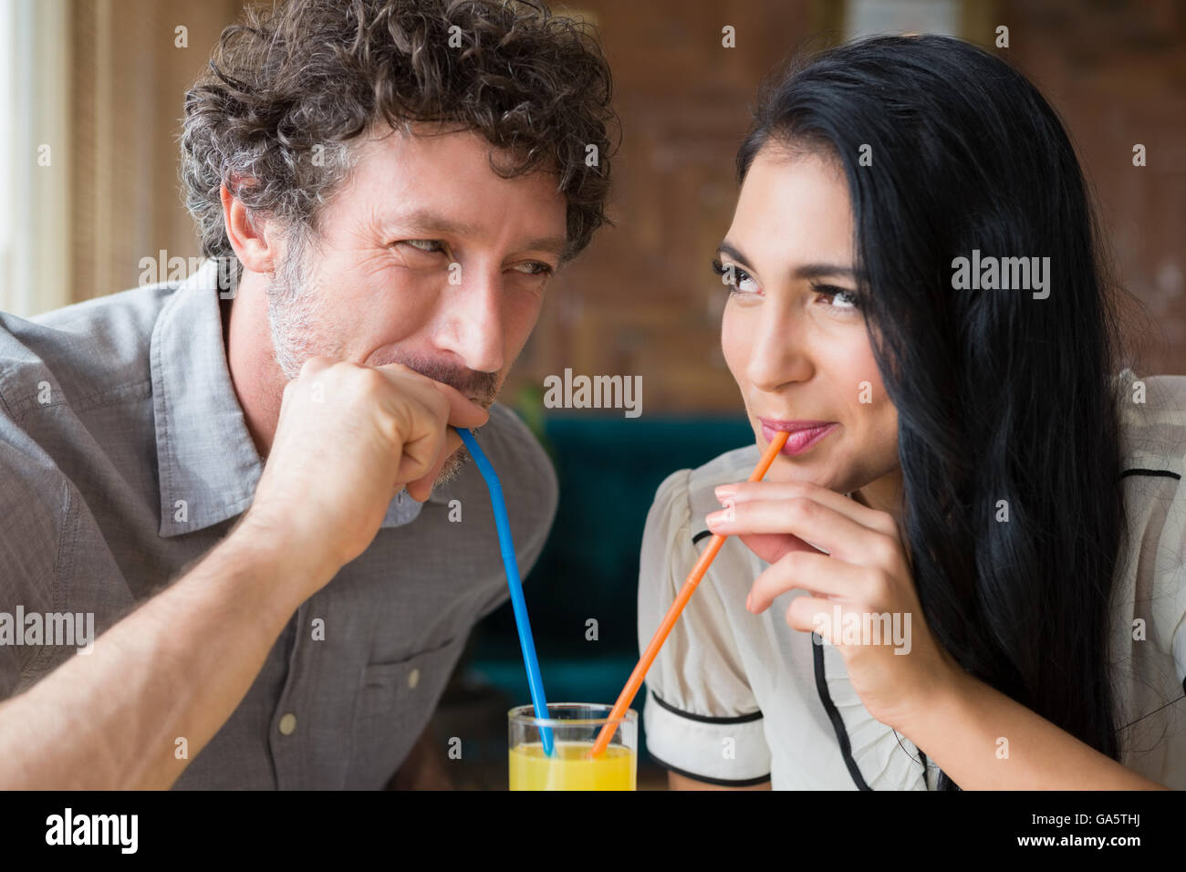 Couple having juice in cafeteria Stock Photo