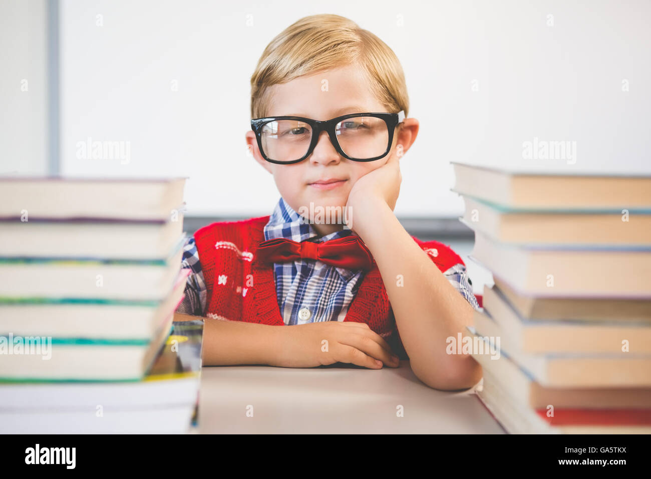 Portrait of schoolkid pretending to be a teacher in classroom Stock Photo