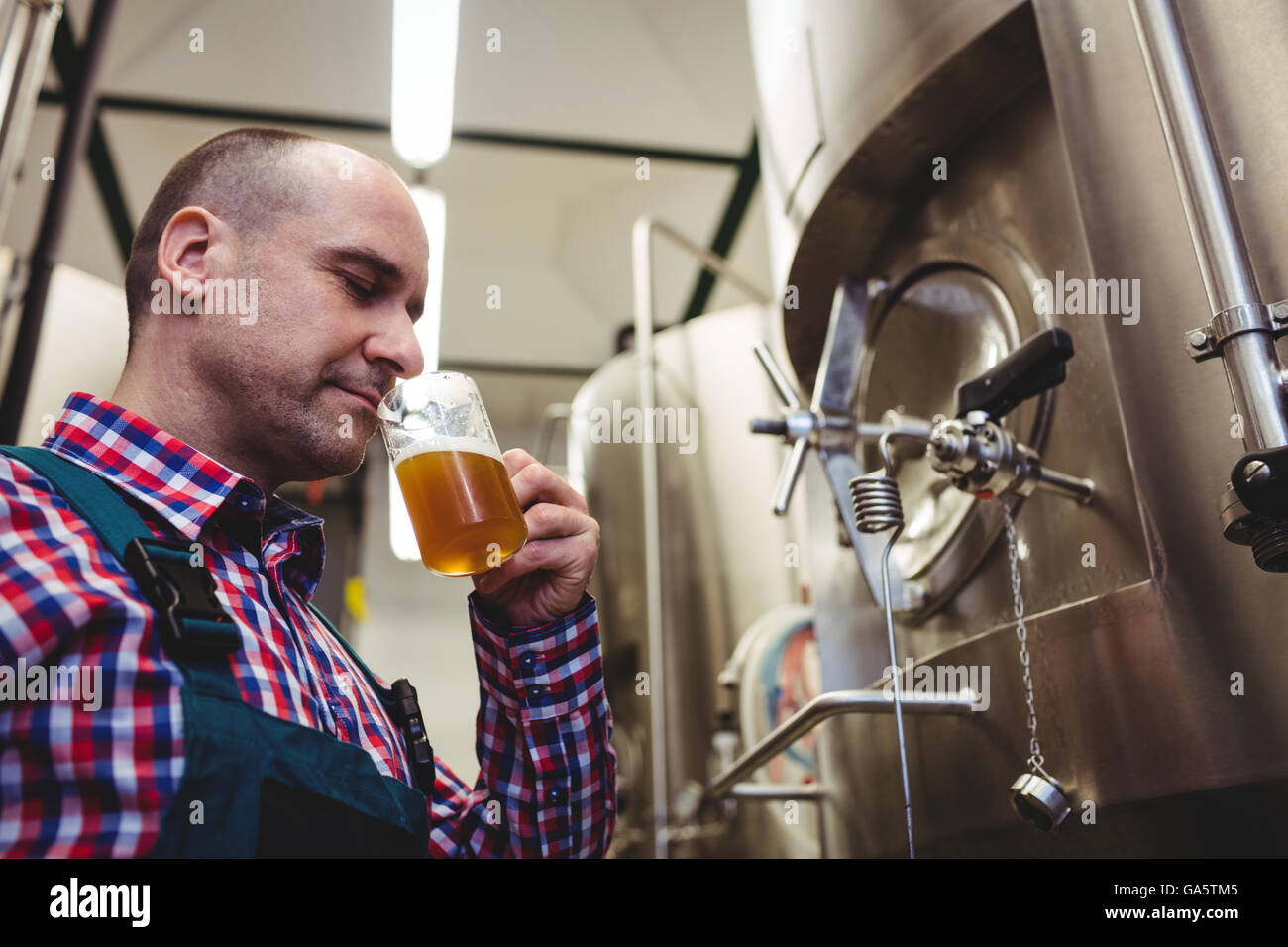 Manufacturer smelling beer at brewery Stock Photo