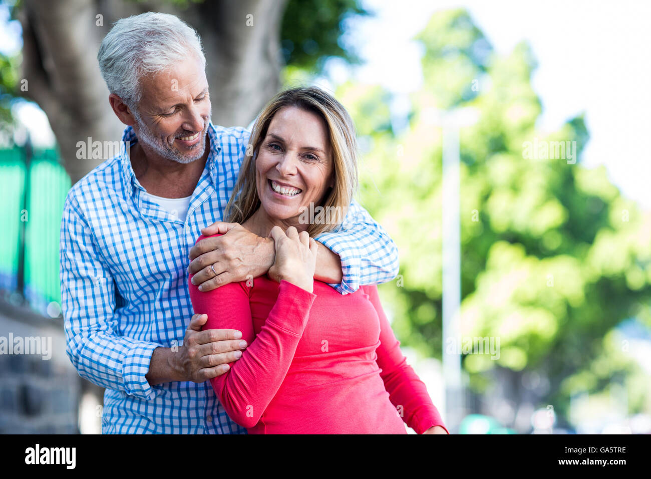 Romantic mature couple against tree Stock Photo - Alamy