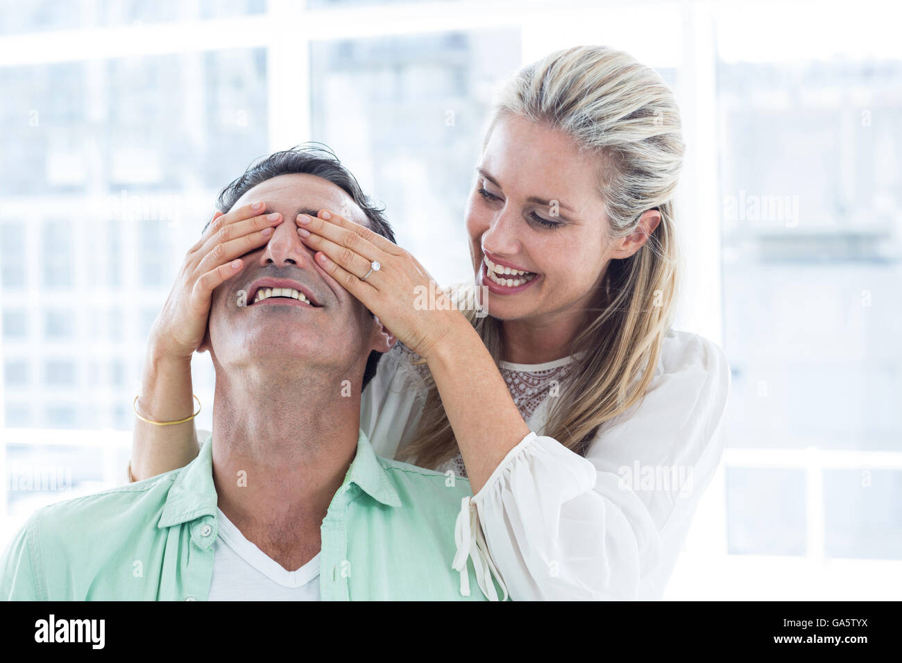 Mid adult woman covering eyes of man Stock Photo