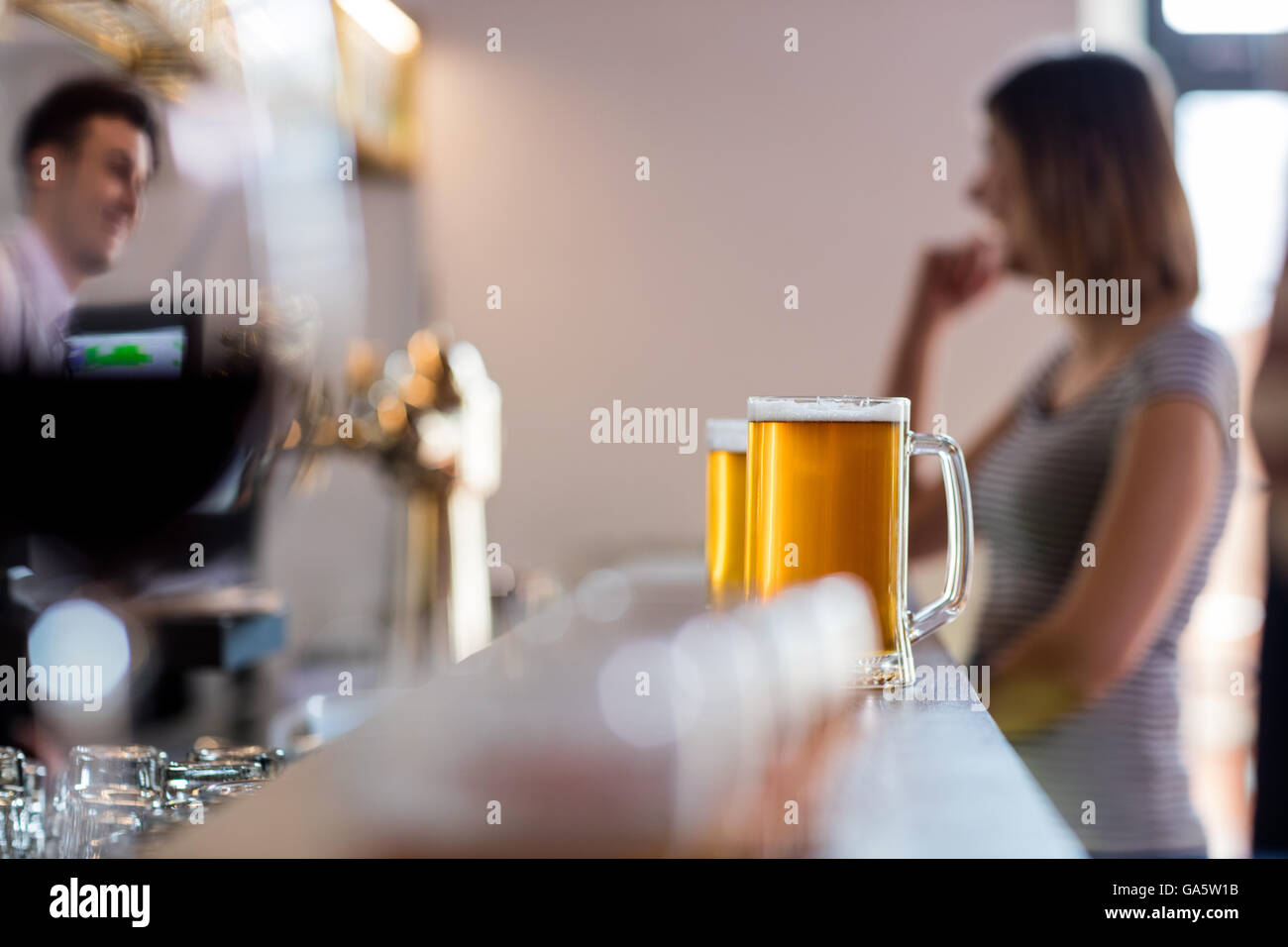Beer mugs on bar counter at restaurant Stock Photo