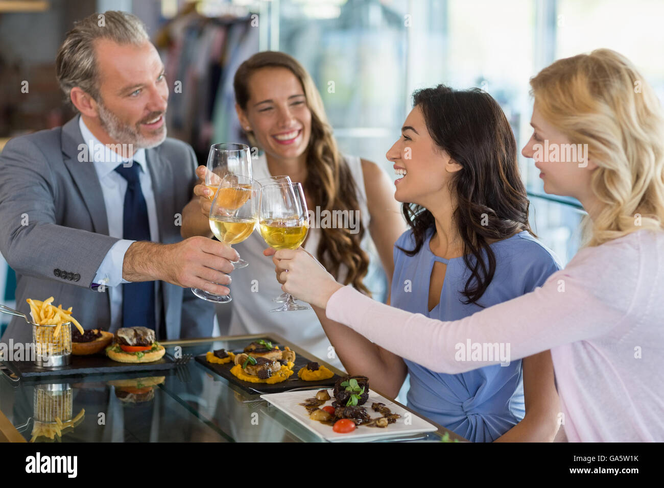 Happy business colleagues toasting beer glasses while having lunch Stock Photo