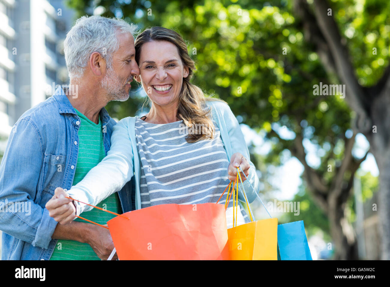 Romantic couple holding shopping bags in city Stock Photo