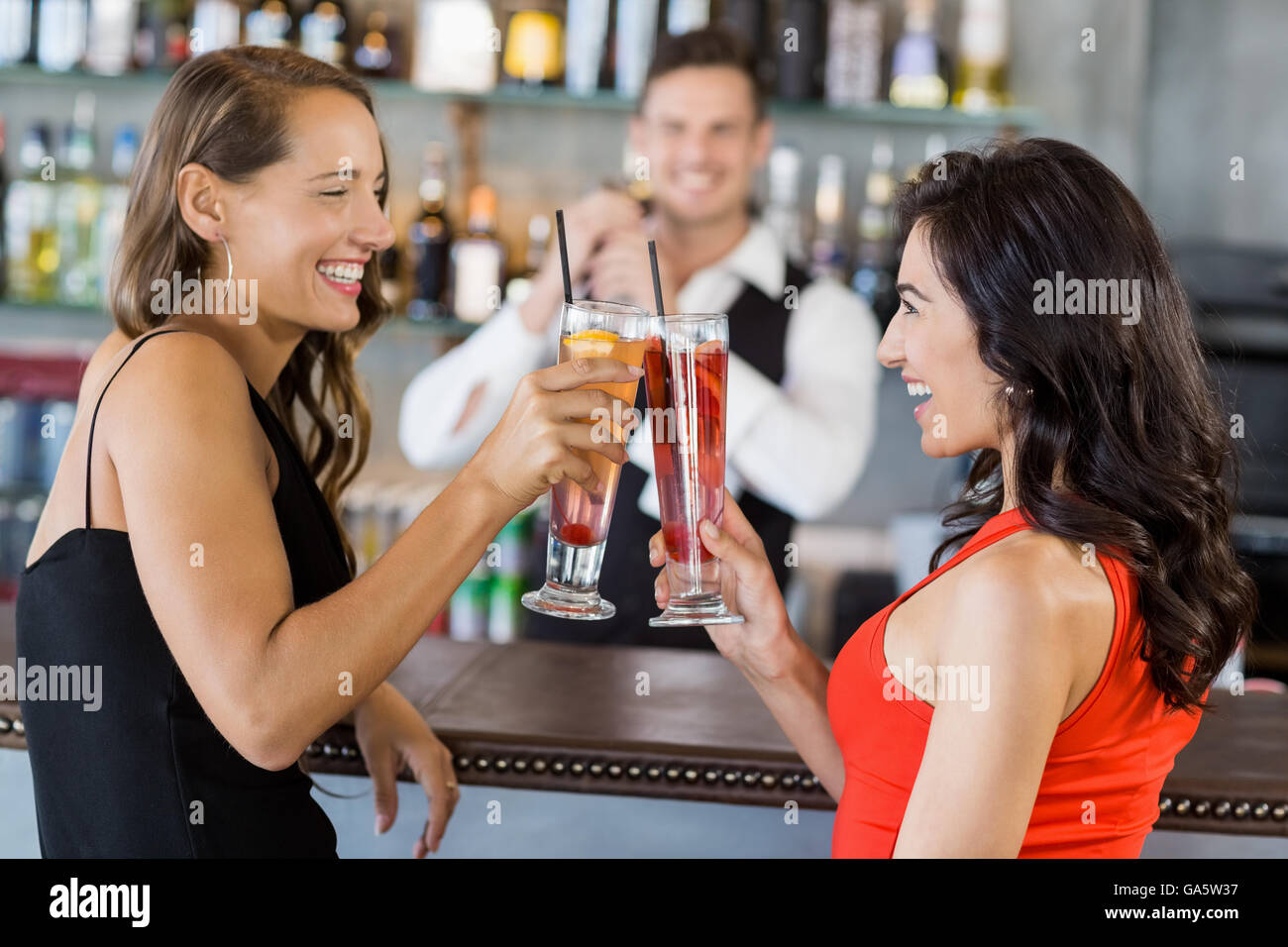 Beautiful women toasting cocktail glasses Stock Photo