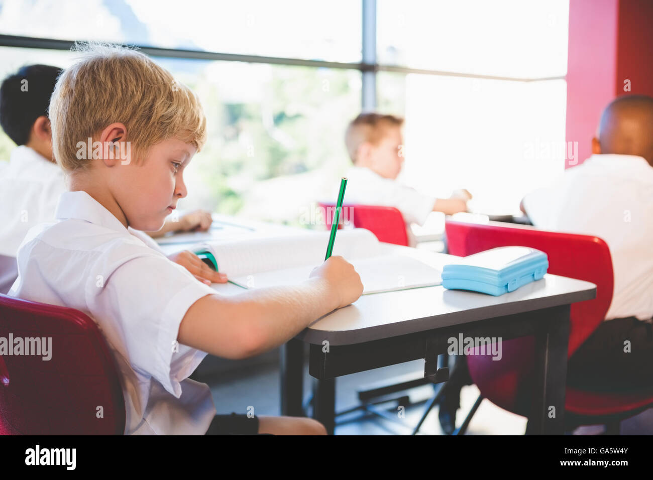 Schoolboy studying in classroom Stock Photo - Alamy