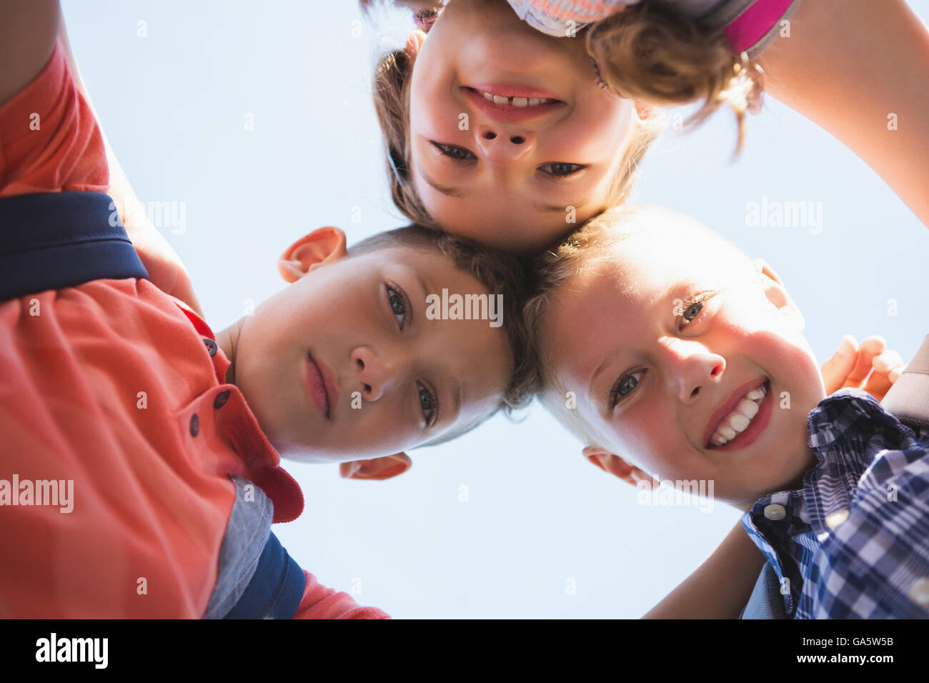 Schoolkids forming huddle in campus Stock Photo