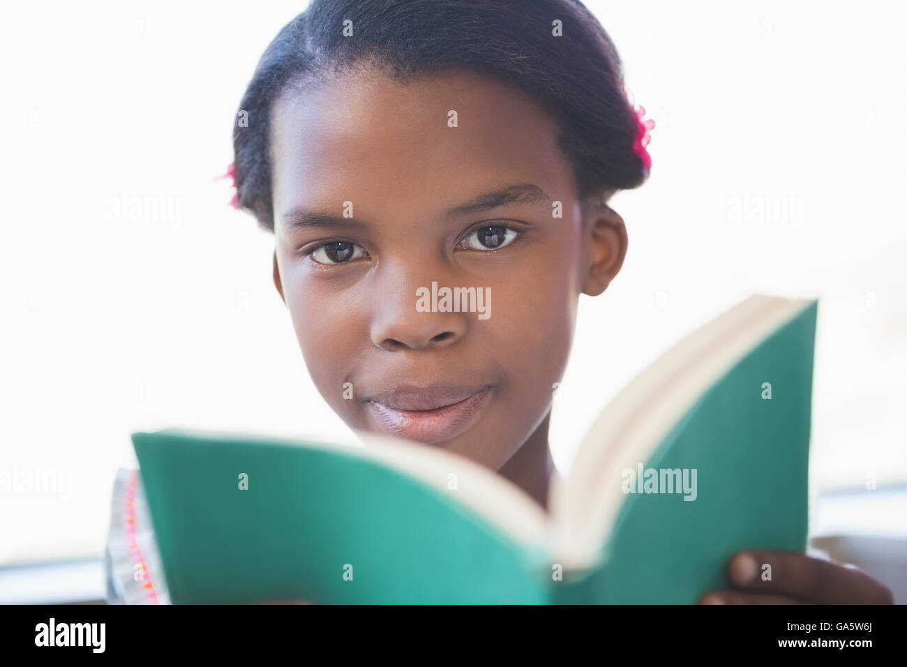 Schoolgirl reading book in library Stock Photo