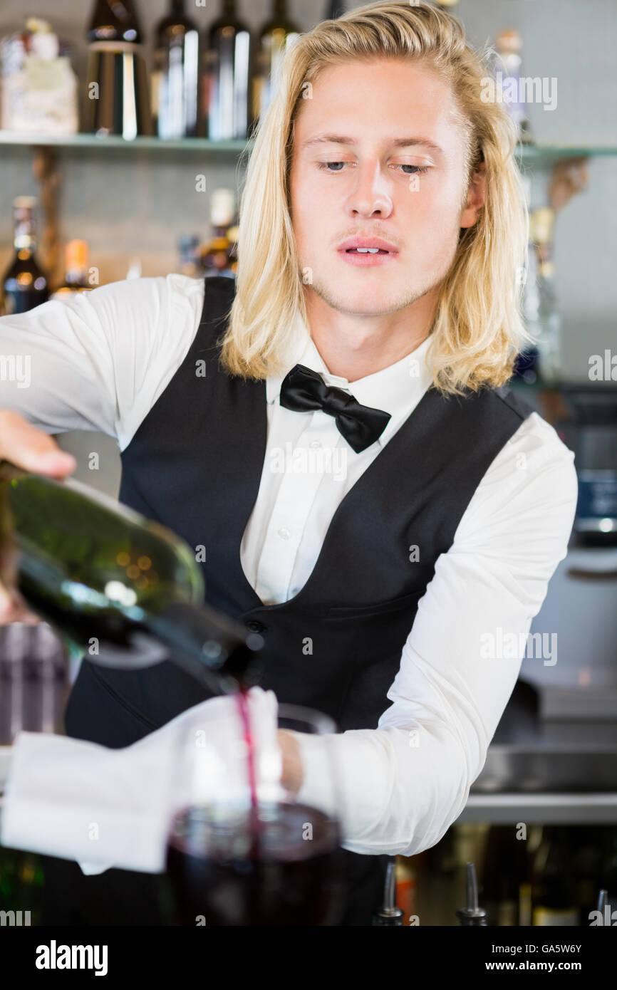 Waiter pouring wine into glass Stock Photo