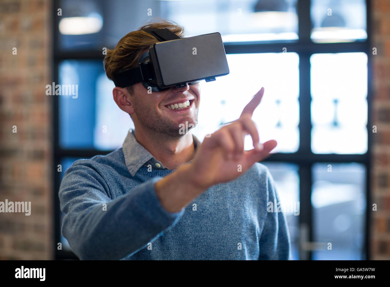 Businessman using virtual reality headset in office Stock Photo