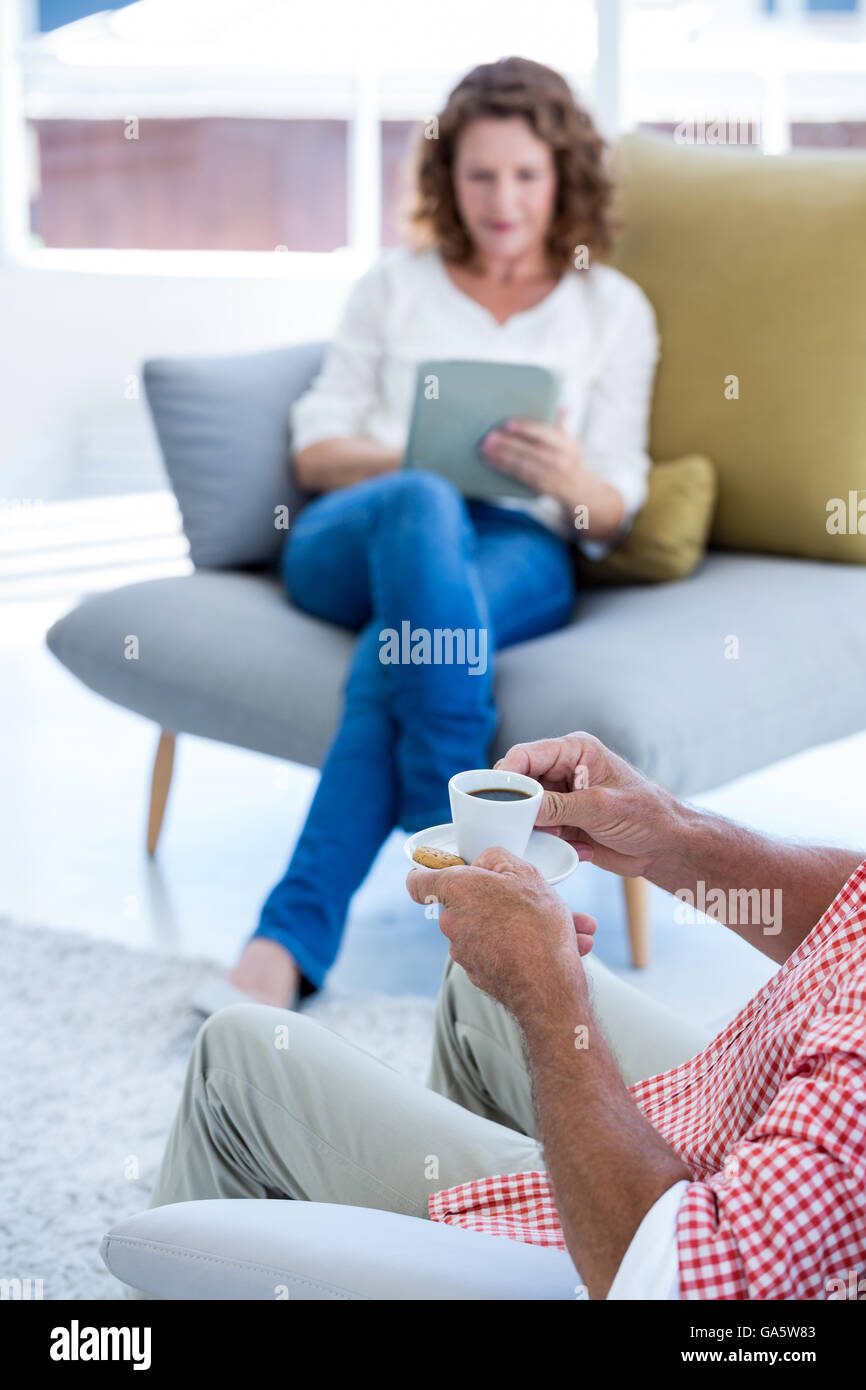 Midsection of man holding coffee cup at home with woman Stock Photo