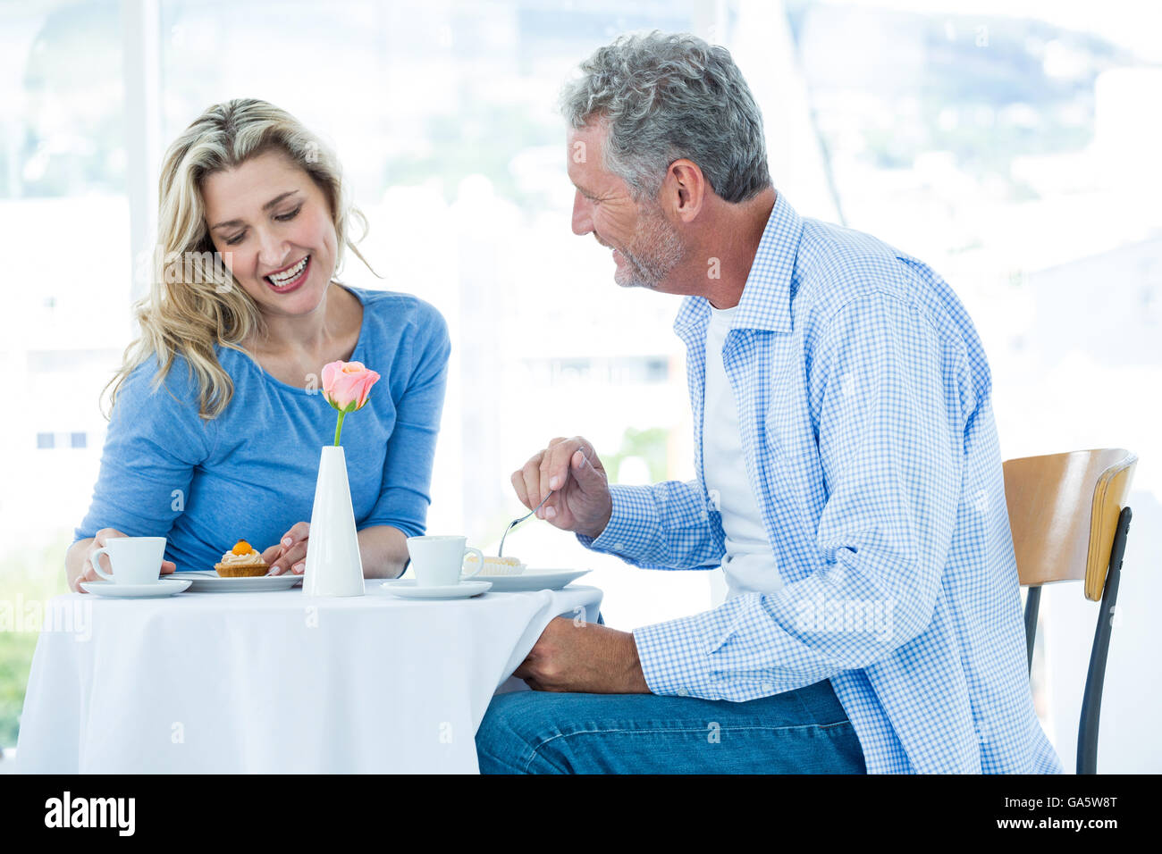 Smiling mature man looking at woman while sitting Stock Photo