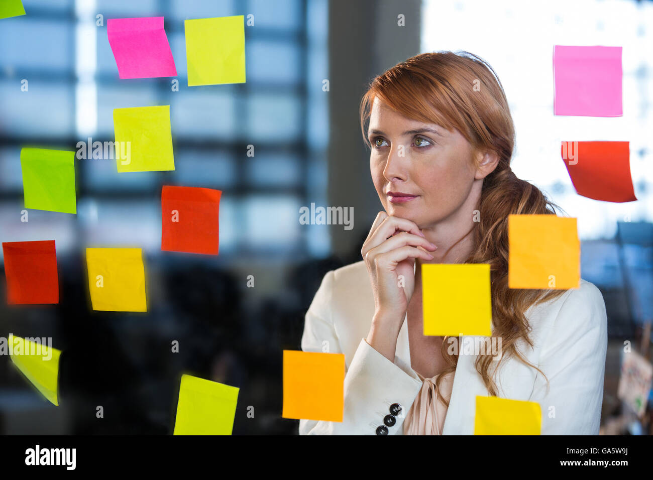 Thoughtful businesswoman looking at sticky notes Stock Photo - Alamy