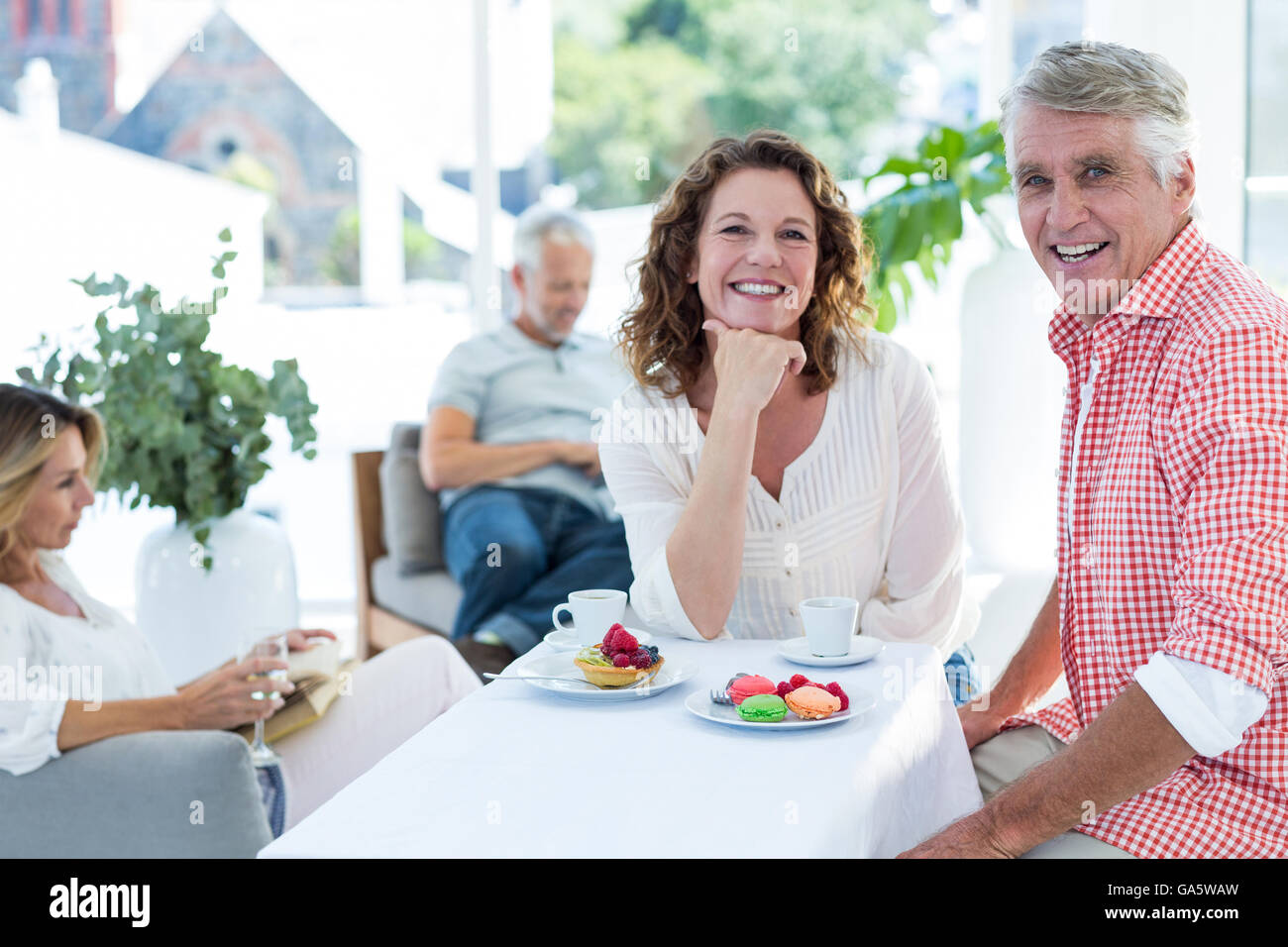 Mature couple smiling while sitting in restaurant Stock Photo