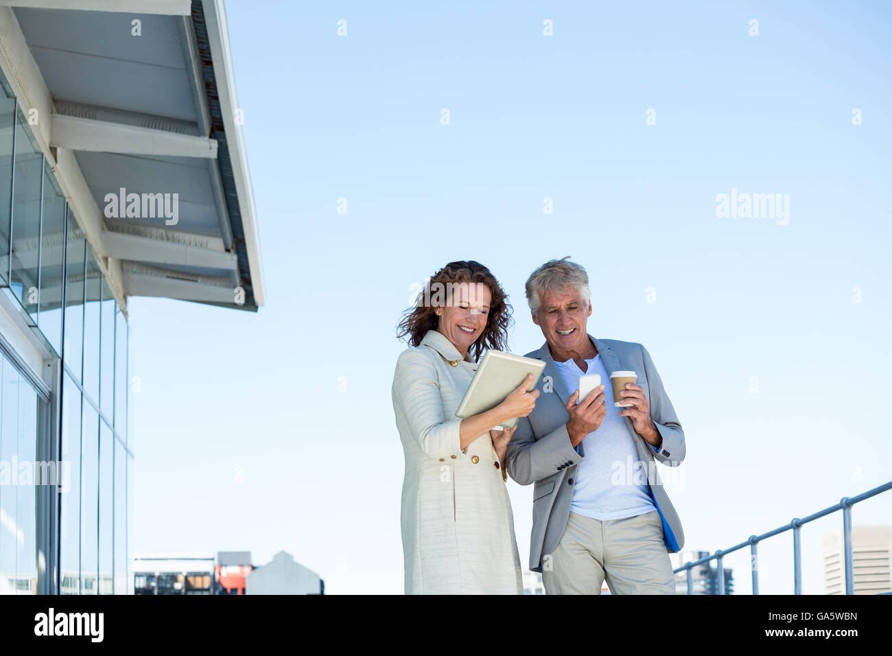 Happy couple using digital tablet and mobile phone Stock Photo