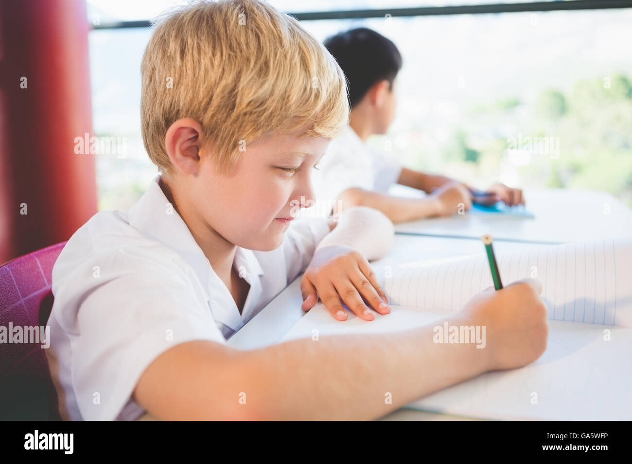 Schoolkid doing homework in classroom Stock Photo Alamy