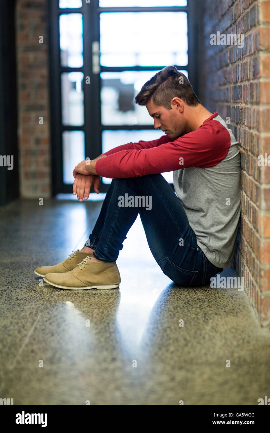 Stressed man sitting in building Stock Photo